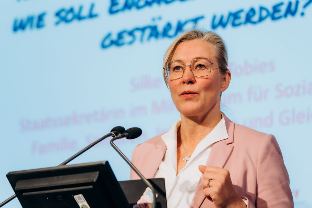 Frau mit Brille steht konzentriert am Rednerpult