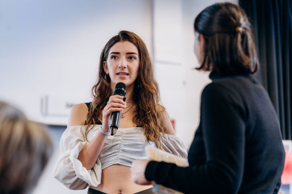 Junge Frau spricht in Mikro