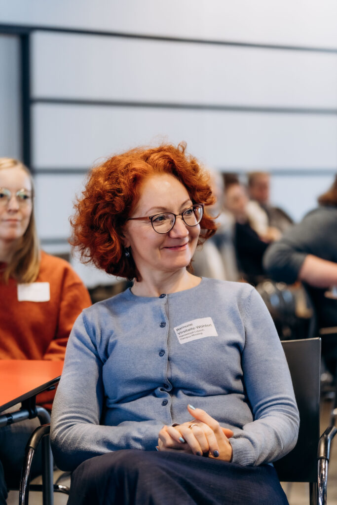 Lächelnde Frau mit roten Haaren und Brille