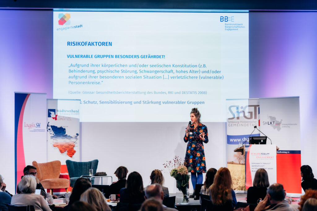 Speakerin auf großer Bühne mit Projektion