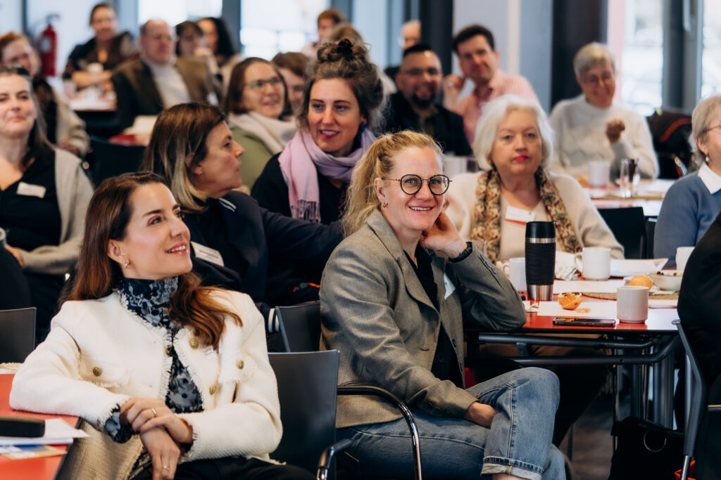 Lächelnde Frauen sitzen an Tischen