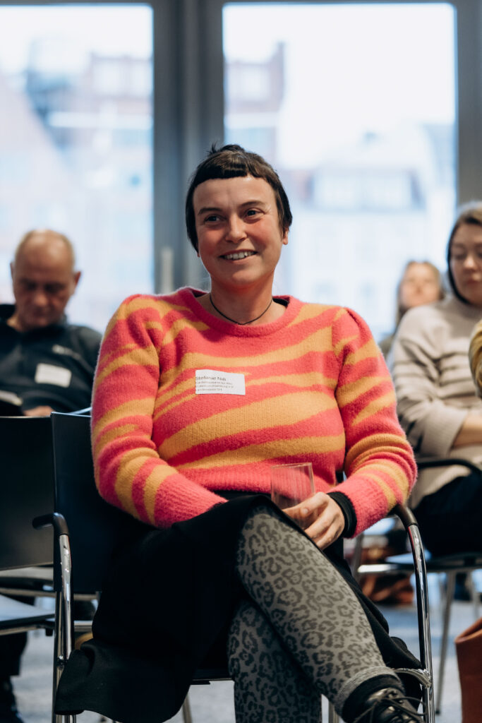 Lächelnde Frau im gelb-orange gestreiften Pullover