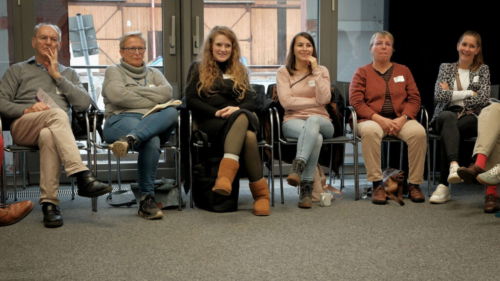 Lächelnde Menschen im Stuhlkreis