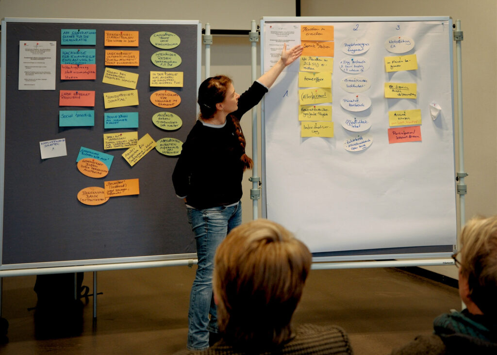 Frau zeigt etwas an Moderationswand