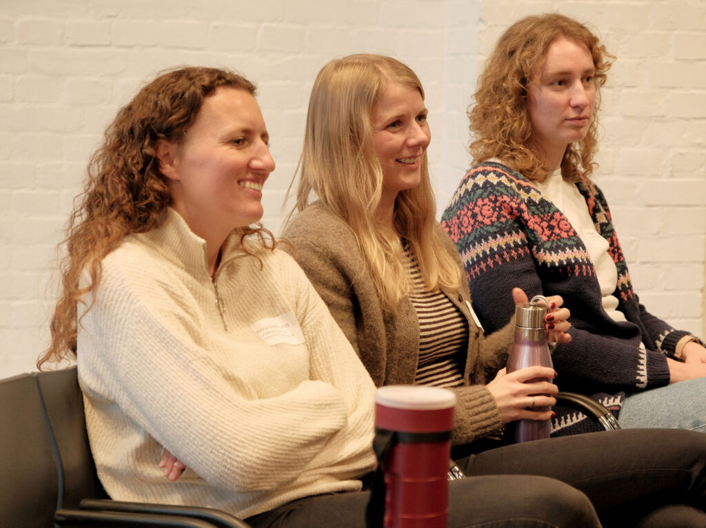 Drei schmunzelnde Frauen nebeneinander