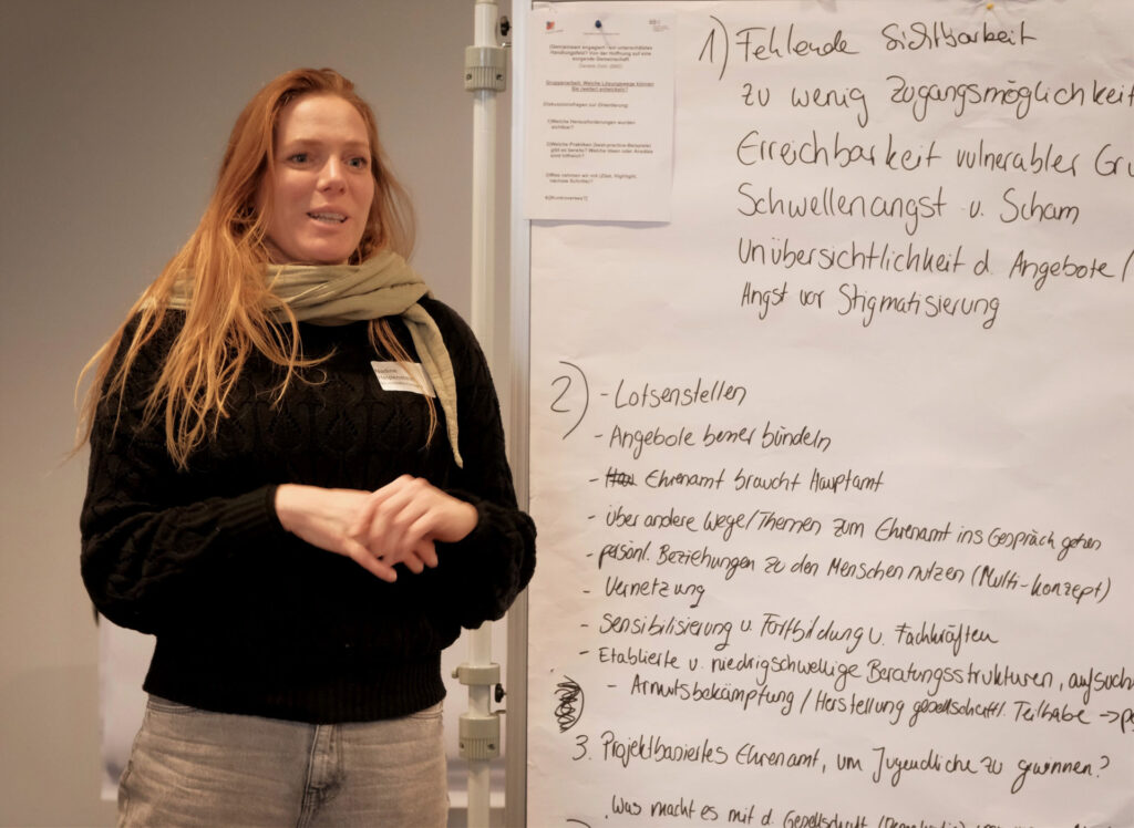 Freudig guckende Frau mit langen hellen Haaren neben Metaplanwand beschriftet