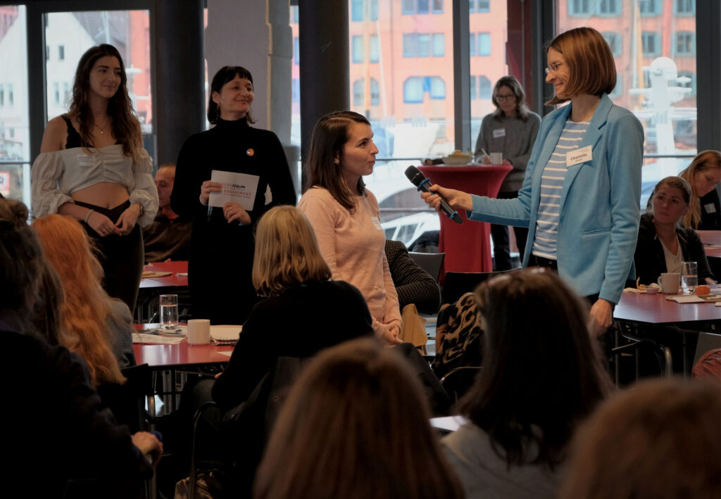 Eine Frau hält einer kleineren Frau ein Mikrofon hin